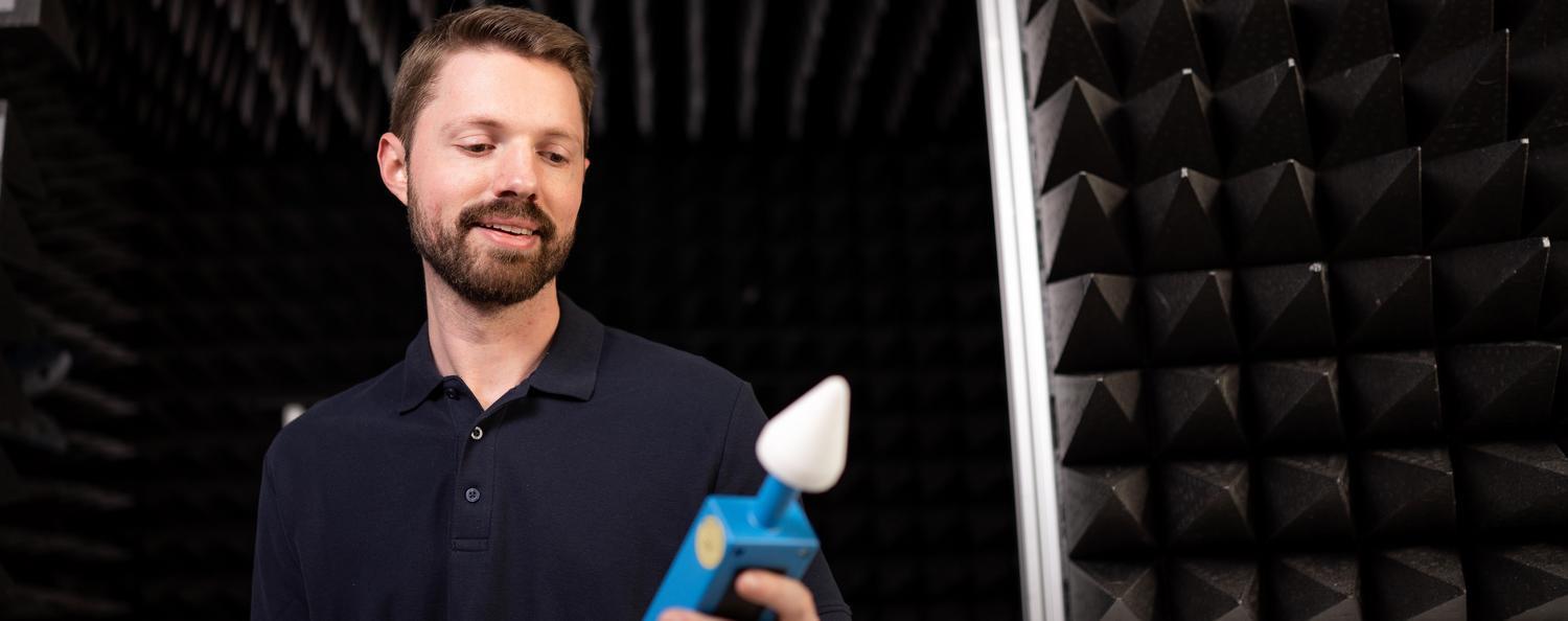 Mikrowellenlecktest in E-Feld-Kammer Mann schaut auf Mikrowellenlecktester. Im Hintergrund sieht man eine E-Feld-Kammer.