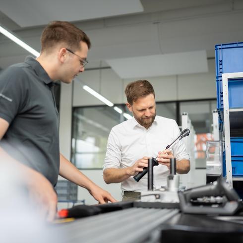 Statistische Prozesslenkung (SPC) Zwei Männer kalibrieren einen Drehmomentschlüssel
