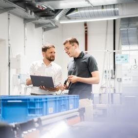 Eignungsnachweise bei attributiven Prüfprozessen Zwei Männer in einem Labor sehen auf einen Laptop