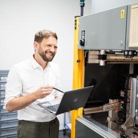 VDA Band 5 – Auflage 3 (07/21) Mann mit Laptop steht vor einen Drehmomentprüfstand